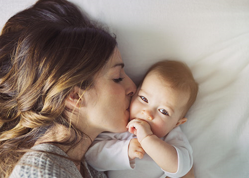 A mother kissing her baby