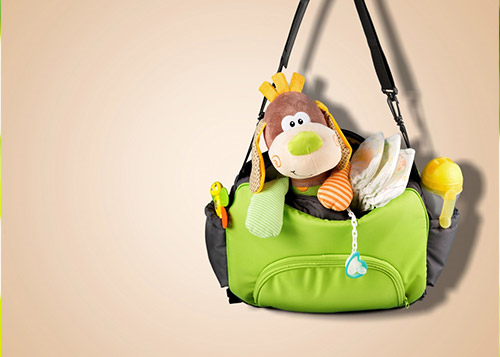 Stuffed toy inside a green diaper bag with black straps