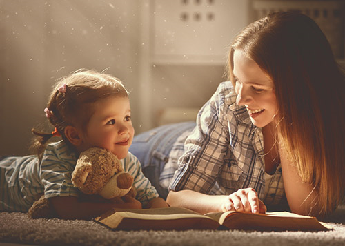 A mother and her young daughter reading a book