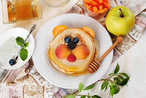 Pancakes for kids with fruits and greens on the side
