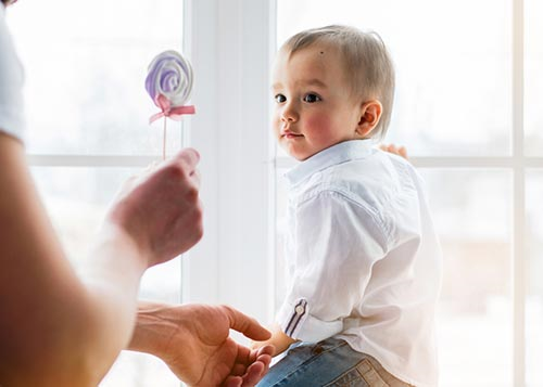 Stranger offering lollipop to a young kid