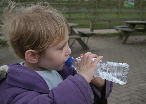 Young boy drinking water from his bottle