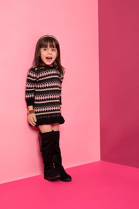 Young girl wearing a black winter dress and black boots