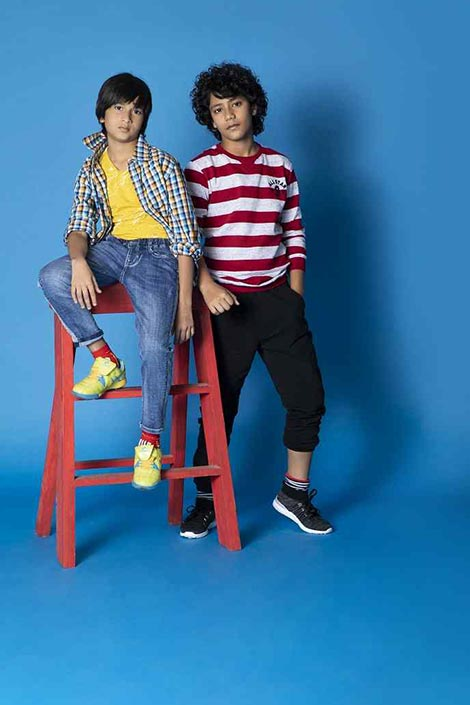 Two young boys in casual outfits posing for the camera