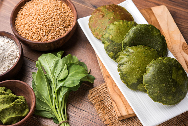 Deep-fried spinach bread on a white serving plate