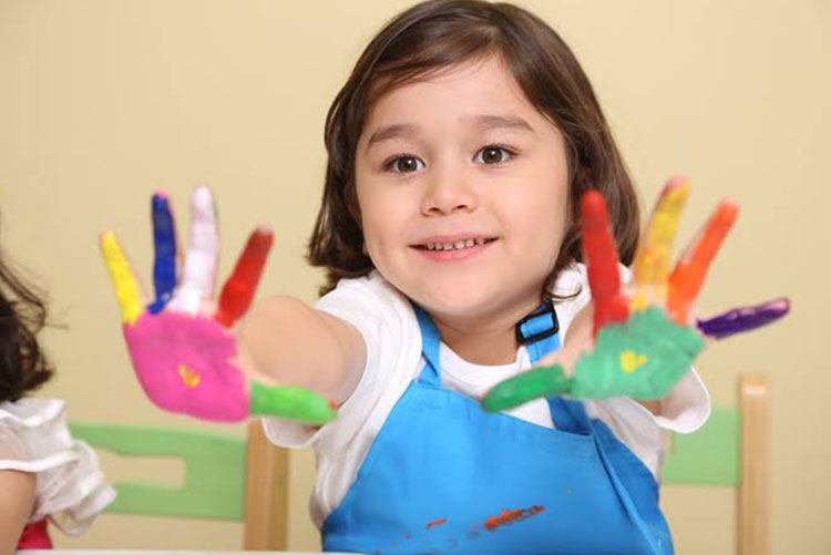 Little girl showing her paint-stained palms