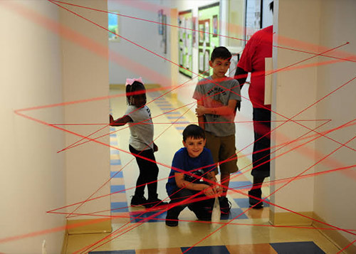 Kids staring at a maze pattern created with strings