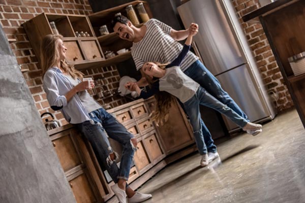 Dad dancing with daughter while mother watches and smiles