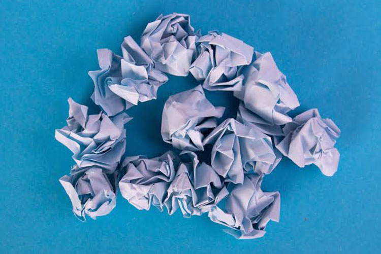 Crumpled up paper balls against a blue background