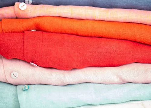 Blue, pink, orange, red, white, and pastel blue shirts arranged on top of each other.