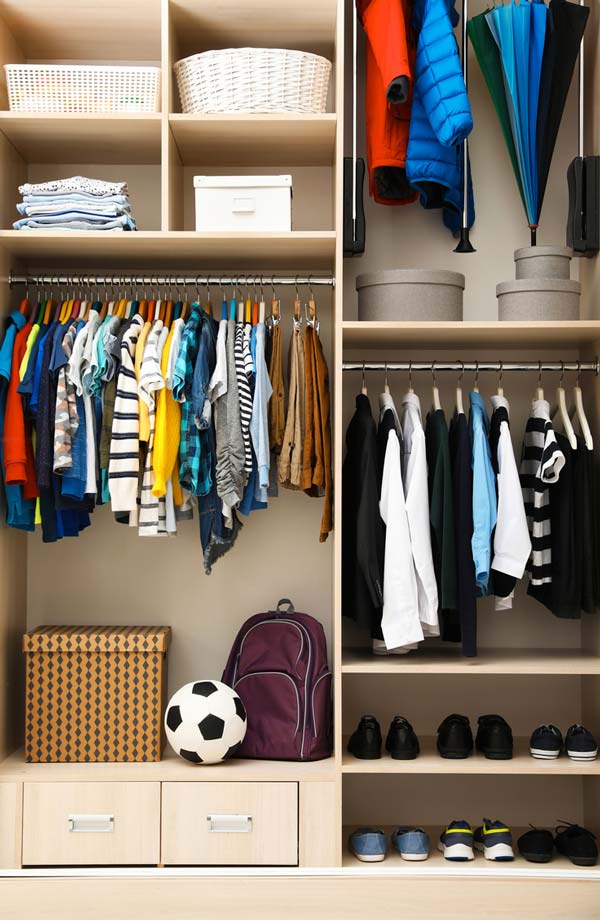 A kids closet with clothes, toys, shoes, and accessories neatly arranged inside. 