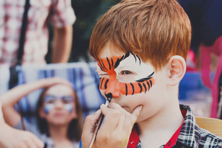 A boy getting his face painted