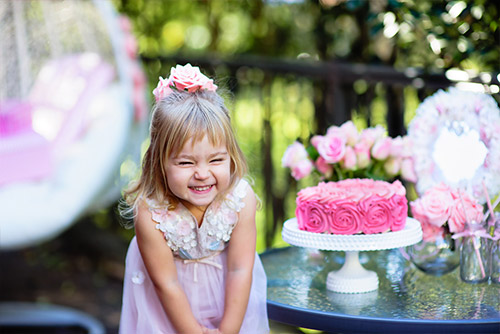 Pretty young girl with a pink floral cake at her birthday bash!