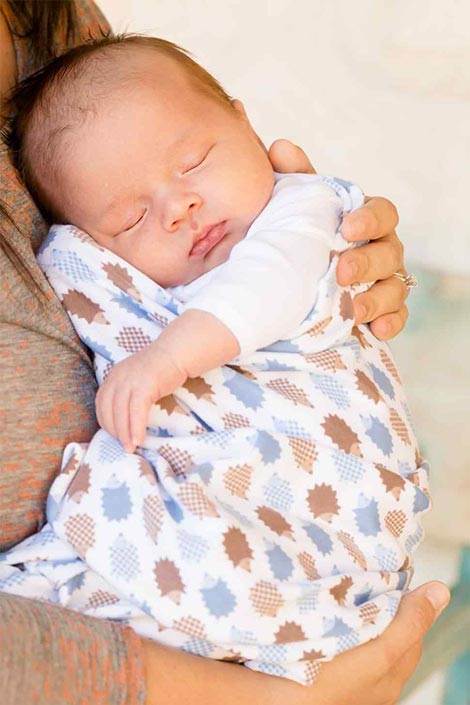 Mother holding baby wrapped in a snuggly blankie