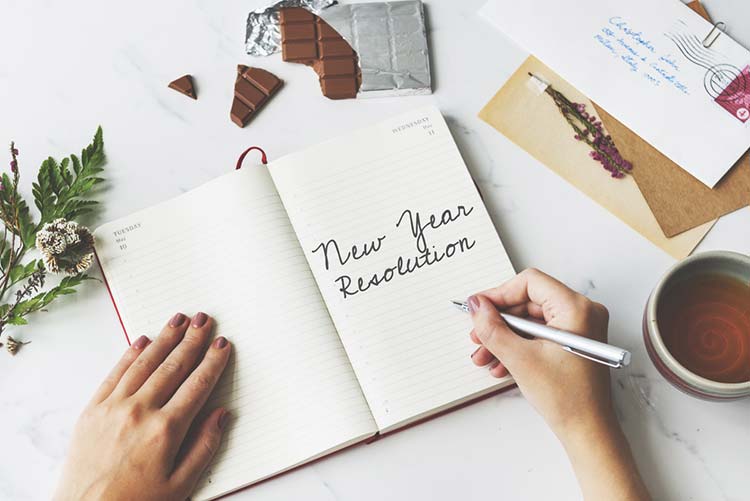 Woman writing down her New Year’s resolutions