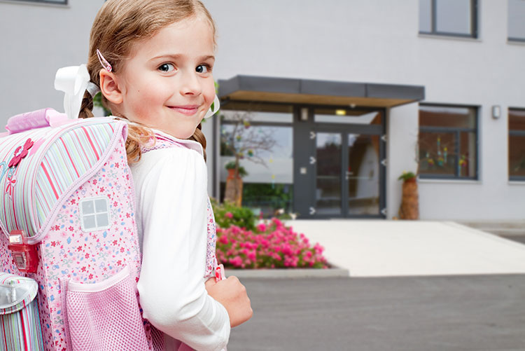 A girl carrying a trendy pink school bag.