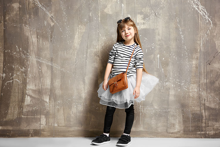 A young girl wearing a trendy sling bag.