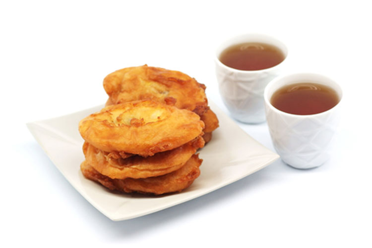 Plate of banana pakoras with two glasses of tea