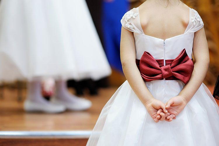 A girl wearing a dress with a beautiful bow.