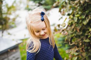 A young girl wearing a bow in her hair.