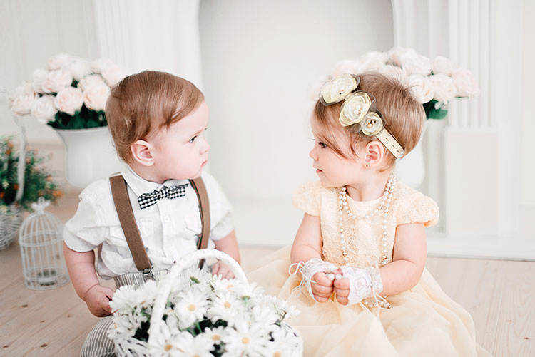Twin babies dressed for a wedding.