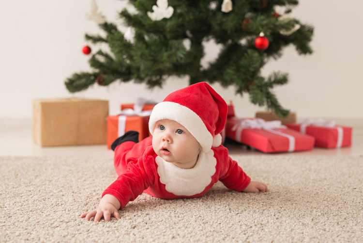 Toddler dressed as Santa Claus crawling on a carpeted floor!