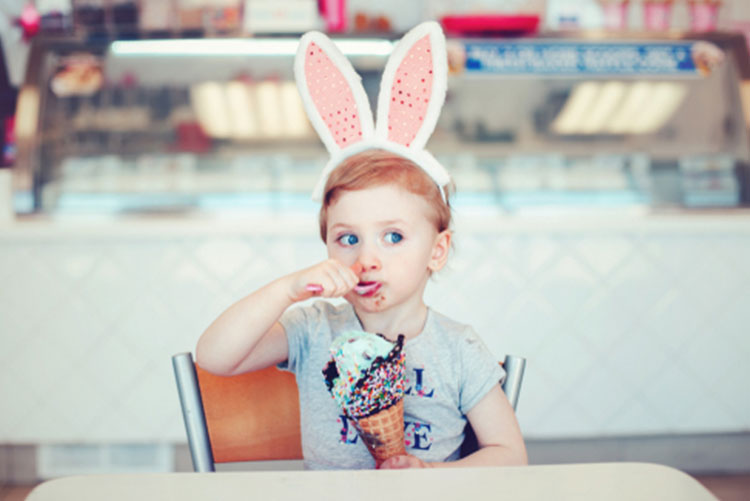 Girl wearing bunny ears eating ice cream