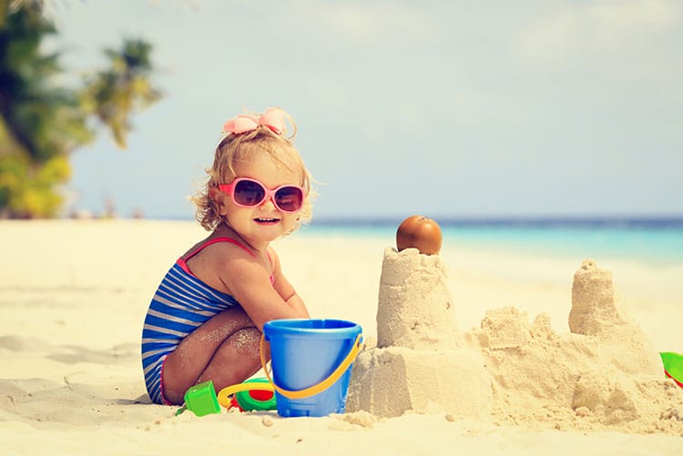 A young girl building sandcastles on the beach!