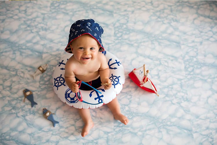 A baby boy sitting in a donut tube.