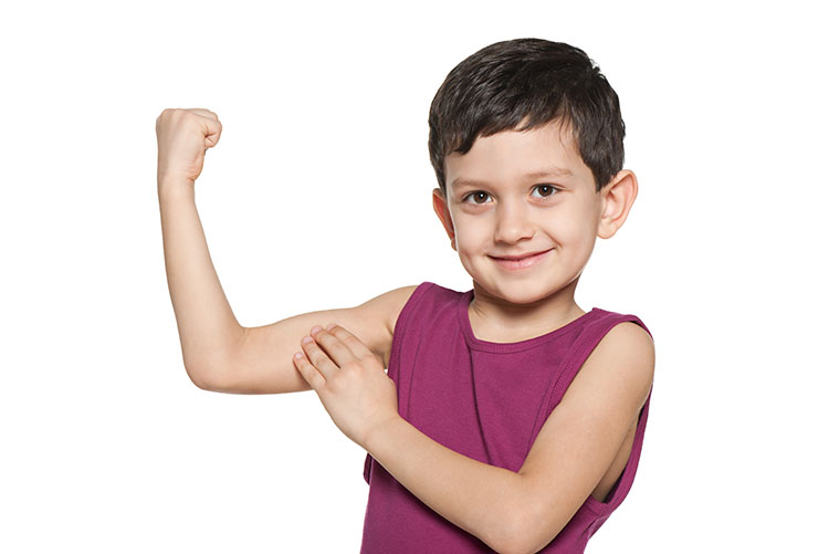 A young boy showing off his muscles.