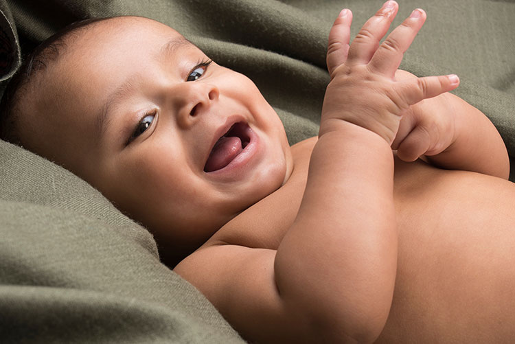 A baby boy smiling at the camera.
