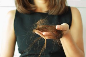 Women holding her fallen hair