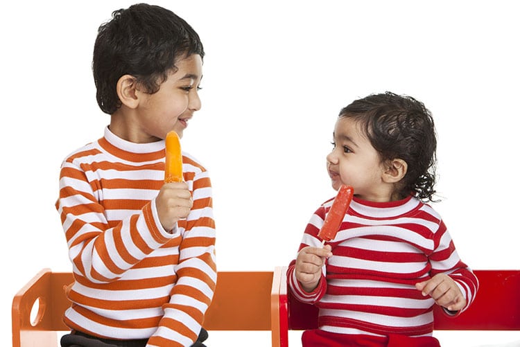 A boy and his sister enjoying Popsicle.