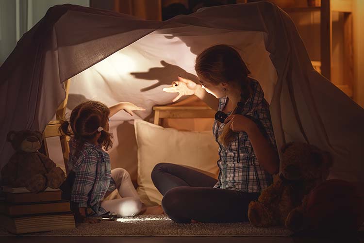 A mom using shadows to tell a story to her daughter.