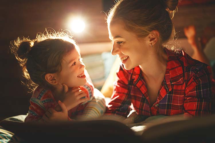 A mother reads a story to her daughter at bedtime.