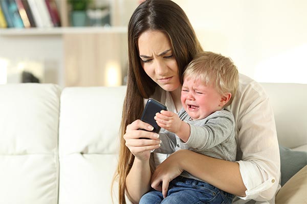 A boy throwing a tantrum to get a phone.