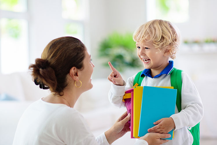 A young boy talking to his mom before leaving to school.