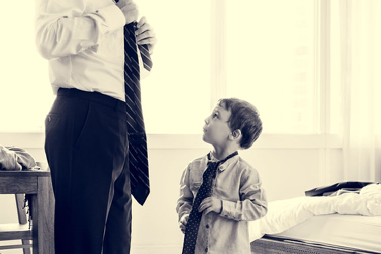 Son imitating his father wearing a tie