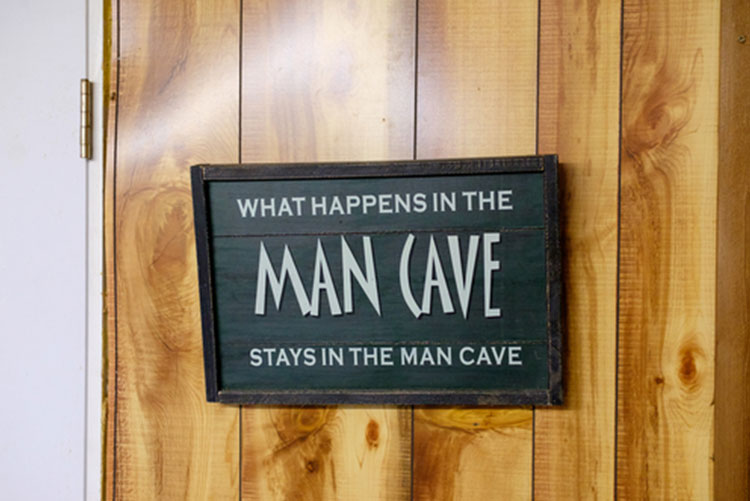 A funny sign with “What happens in the man cave stays in the man cave” written on it