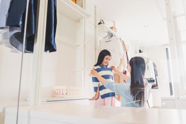 Mother dressing her daughter