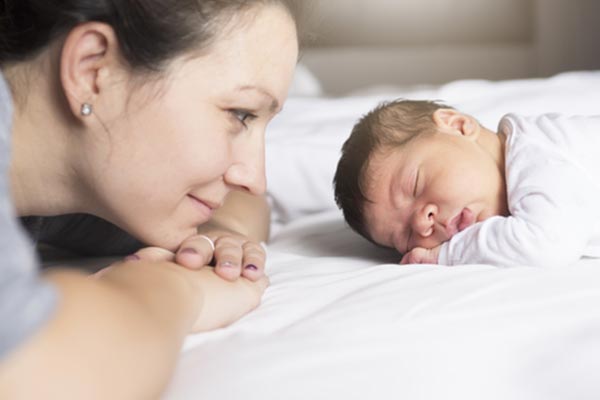 Mother looking at sleeping baby