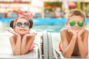 A young boy and girl wearing sunglasses.