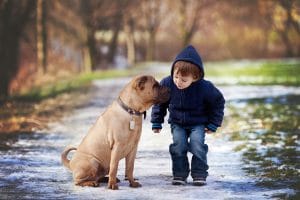 Adorable boy in winter attire giving his dog a kiss!