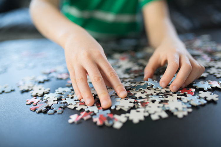 Kids hands sorting through puzzle pieces