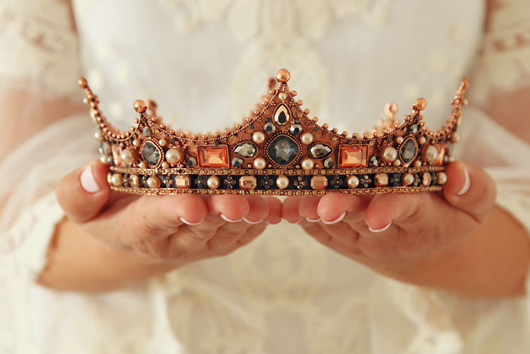Woman holding a bejewelled crown in her hands