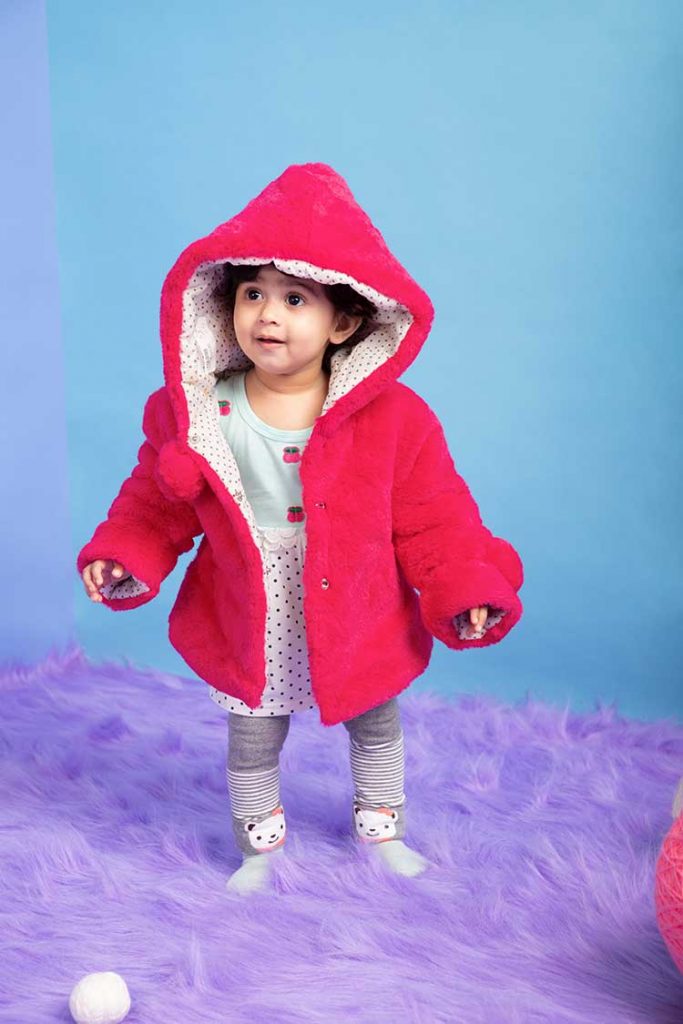 An adorable young girl wearing a reversible jacket
