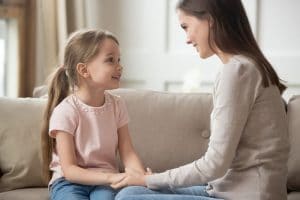 Mother and daughter holding hands and conversing on a couch!