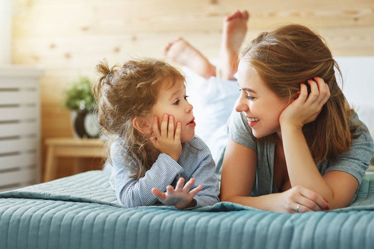 Mother and daughter having a conversation on the bed