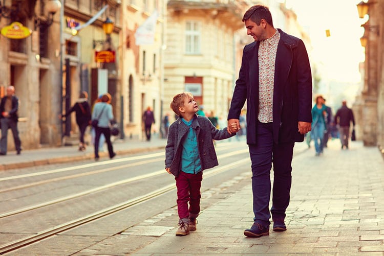 Father and son walking down an old city street, looking sharp.