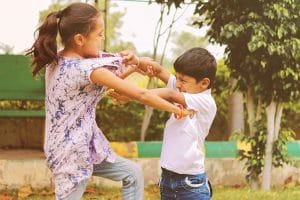 A sister and brother fighting with each other.